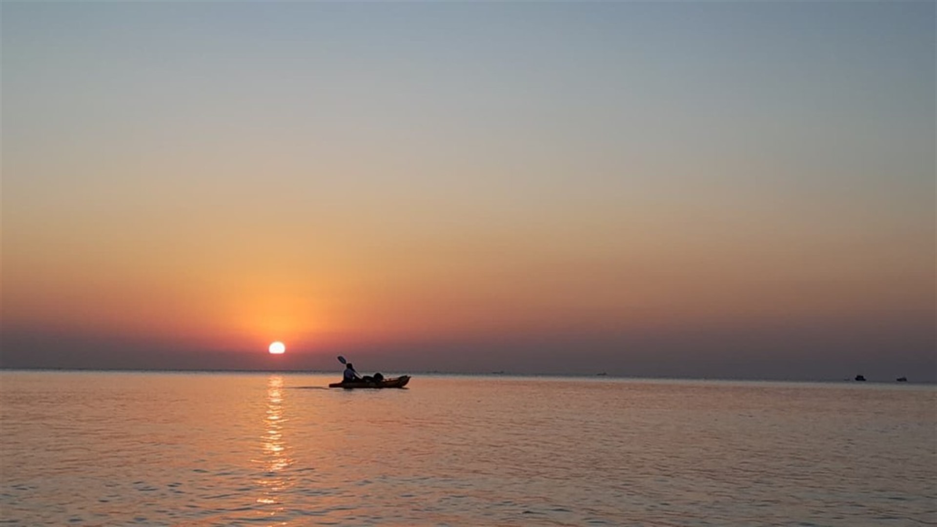 Canoa ao pôr do sol no oceano